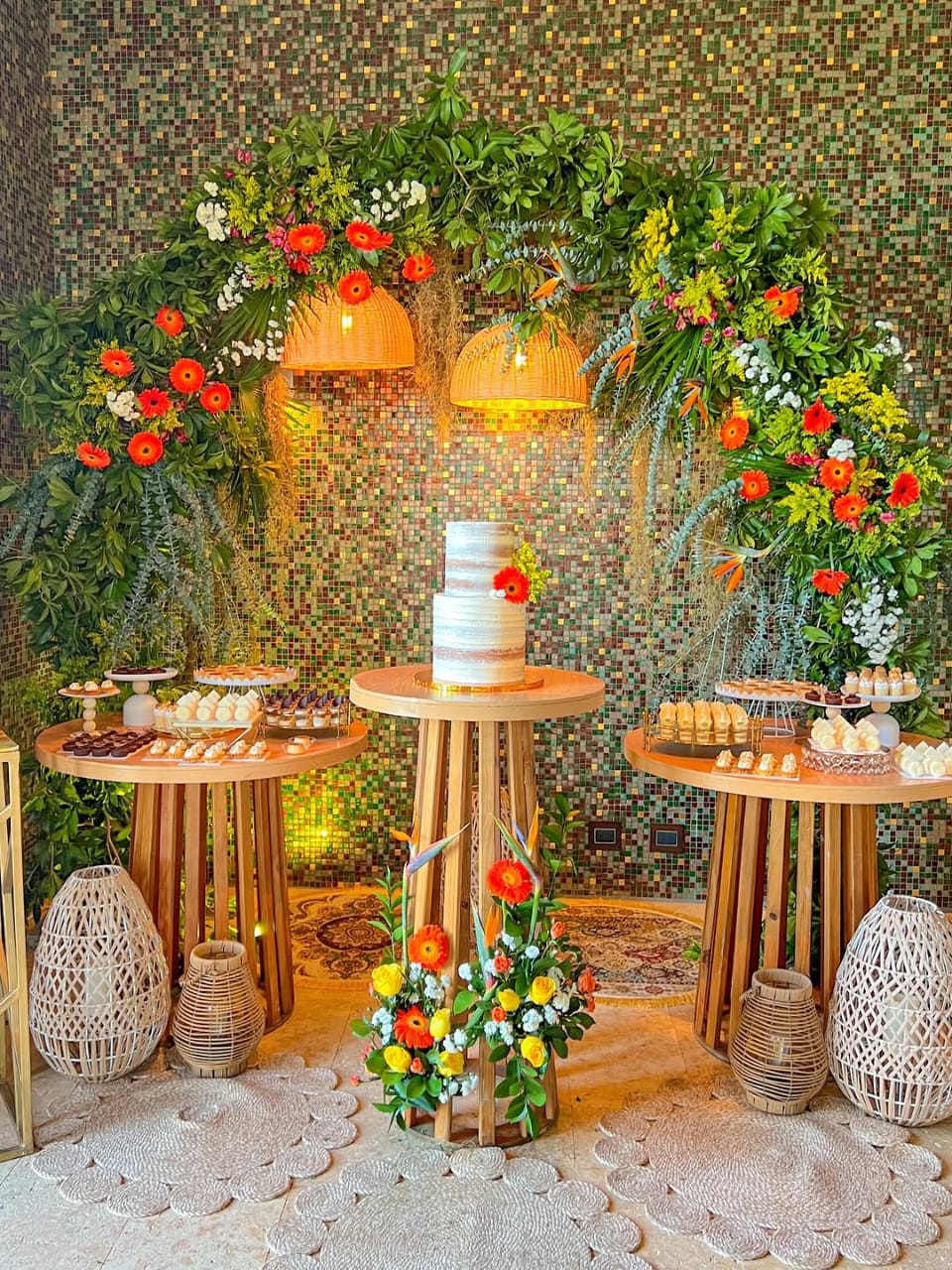 Mesa de dulces premium con arco tropical e iluminación decorativa